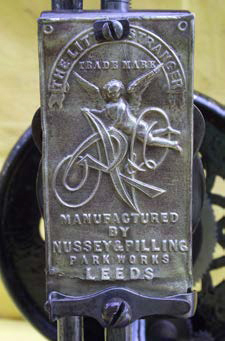 Brass front plate of the Little Stranger Sewing Machine